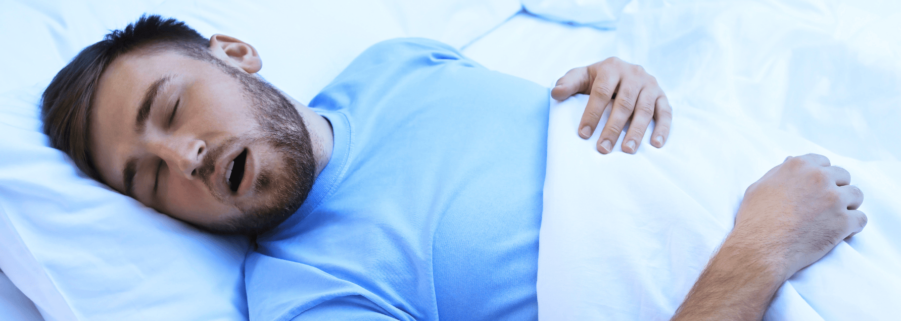 man sleeping in bed with his mouth open